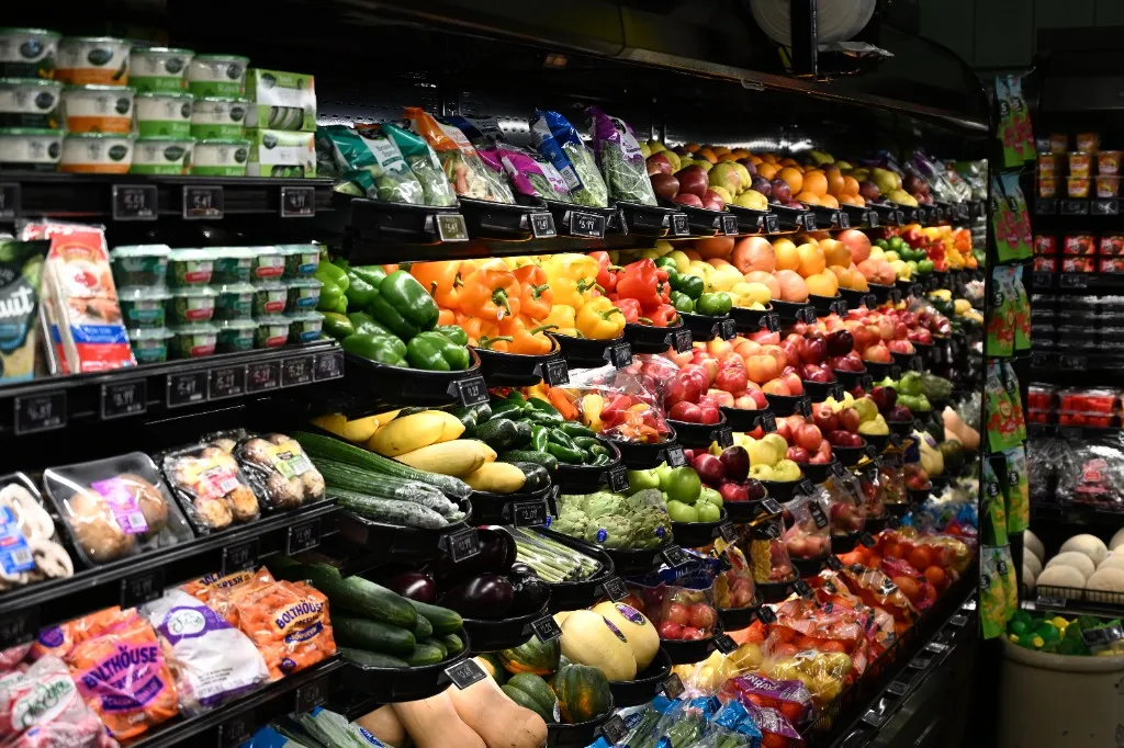 Fresh produce shelves at Farm Country Meats & Market in Union, Missouri, stocked with peppers, squash, apples, and packaged vegetables.