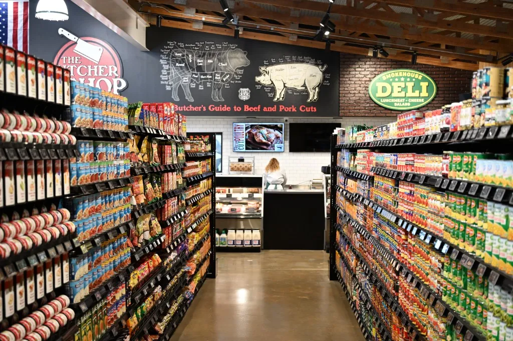Grocery aisles at Farm Country Meats & Market in Union, Missouri, stocked with packaged dry goods and facing the butcher shop and smokehouse deli.